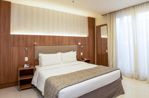 a hotel room with a large bed and a window at Hotel Astoria Copacabana in Rio de Janeiro