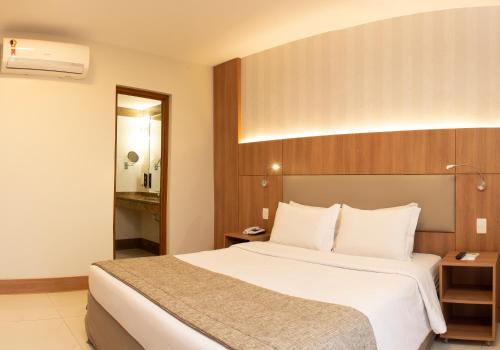 una camera d'albergo con un grande letto bianco di Hotel Astoria Copacabana a Rio de Janeiro