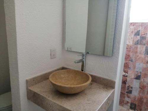 a bathroom with a bowl sink and a mirror at Hotel Villa Mexicana Puerto Escondido in Puerto Escondido