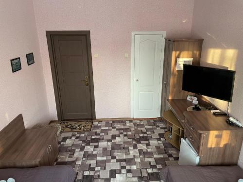 a room with a living room with a tv and a desk at Отель "Natali" in Mykolaiv