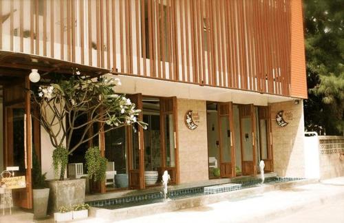 a facade of a building with glass doors and plants at Goodnight Cha Am Minitel in Cha Am