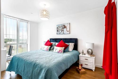 a white bedroom with a bed with red pillows at STYLISH 2 BED/2 BATH, PARKING - BRACKNELL CENTRE in Bracknell