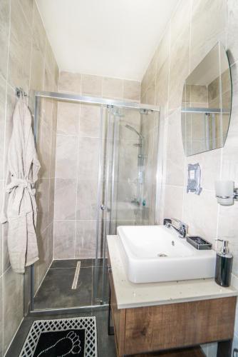 a bathroom with a shower and a sink at Chardonnay Guest Studio Rooms with Great view for nature lovers in Kérynia