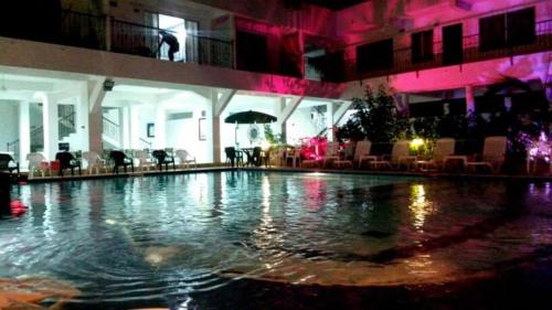 a swimming pool in a hotel with pink lighting at Hotel Cacique Guaicani in Melgar