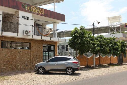 a silver car parked in front of a building at Hotel Cacique Guaicani in Melgar