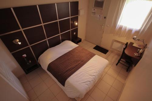 - une petite chambre avec un lit et un bureau dans l'établissement Résidence Côté Sud La Bouilladisse, à La Bouilladisse