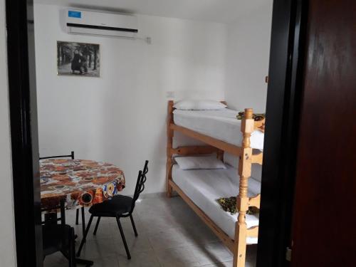 a room with two bunk beds and a table at La Nona in Villa Cura Brochero