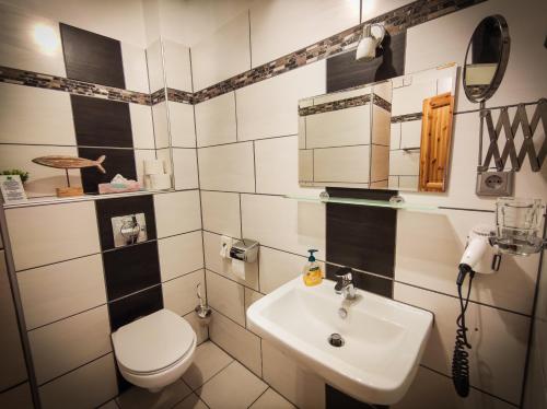 a bathroom with a toilet and a sink at Hotel Landgasthof Sonne in Mahlberg