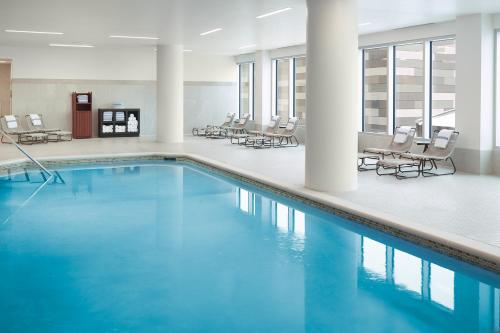 a pool with chairs and tables in a building at Omni Viking Lakes in Eagan