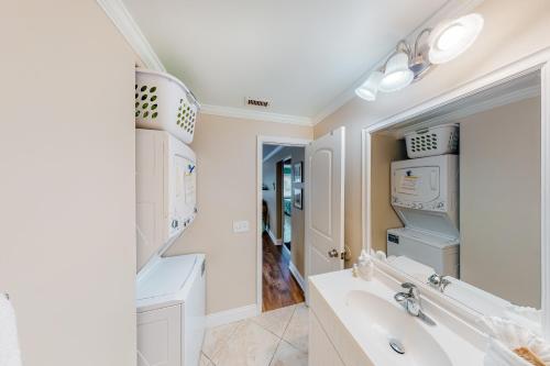 a white bathroom with a sink and a mirror at Sea Pirate 1 in Holmes Beach