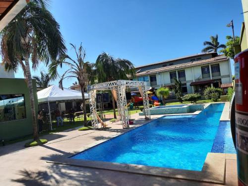 a pool at a resort with a swing and a pool at Hotel Pousada da Serra in Maracaju