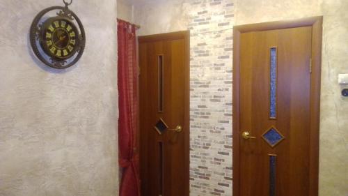 プシュキンスキエ・ゴリにあるPhilisa Na Turbazeの壁にドアと時計が付いた部屋