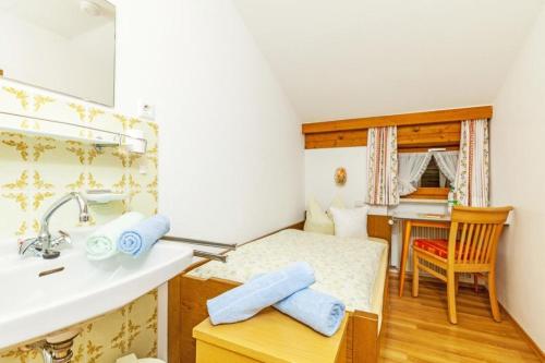 een badkamer met een wastafel en een bed in een kamer bij Gästehaus Else in Reit im Winkl