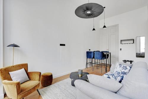 a living room with a couch and chairs and a table at Maison Labruyère Bordeaux - Jardin Public in Bordeaux