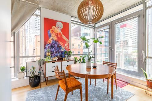 a dining room with a table and some windows at Spacious and Quiet Corner Apartment Downtown Toronto in Toronto