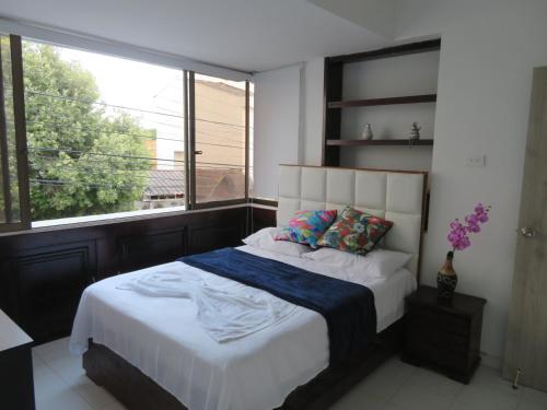 1 dormitorio con 1 cama y ventana grande en SAN JACINTO HOSTEL en Cartagena de Indias