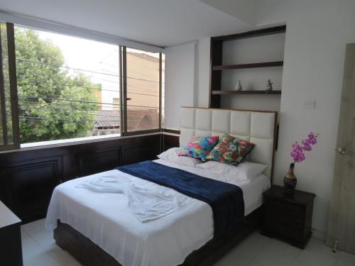 Schlafzimmer mit einem Bett und einem großen Fenster in der Unterkunft SAN JACINTO HOSTEL in Cartagena de Indias