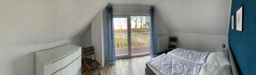 a bedroom with a bed and a large window at Boddenhus Loissin in Loissin