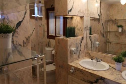 ein Badezimmer mit einem Waschbecken, einem WC und einem Spiegel in der Unterkunft VILLA CERCA DE LA PLAYA,PISCINA PRIVADA,BBq in Málaga