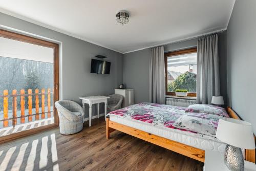 a bedroom with a bed and a balcony at Enklawa u Zosi in Szczawnica