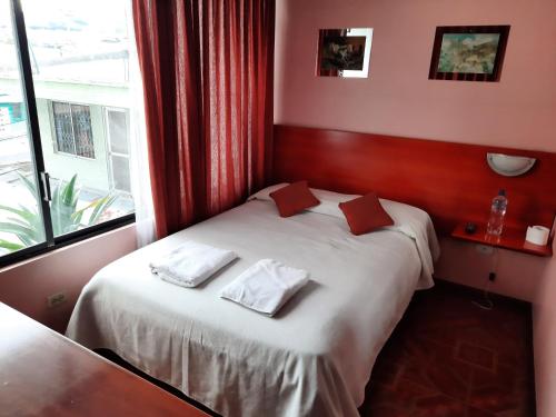ein Schlafzimmer mit einem Bett mit zwei Handtüchern darauf in der Unterkunft Hostal Sauna Water Palace in Quito