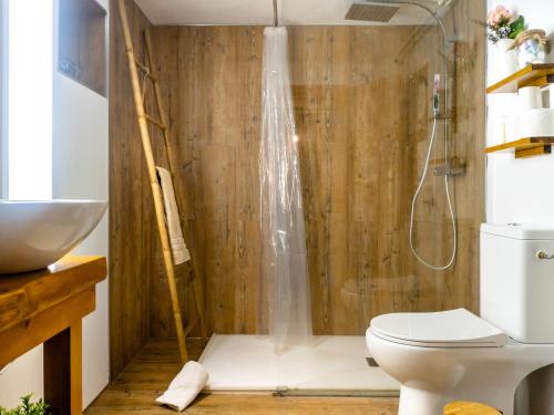 uma casa de banho com um chuveiro e um WC. em Refúgio do Óscar em Gavieira