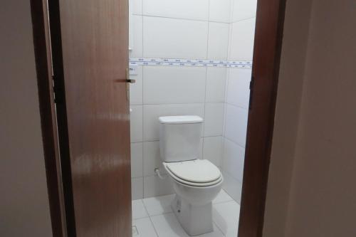 a bathroom with a white toilet in a room at Chalé no Caborê in Paraty