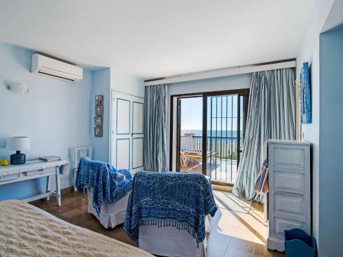 a bedroom with a bed and a desk and a balcony at Magnificent Villa in Andalusia near Beach in La Cala de Mijas