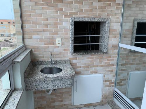 a bathroom with a sink in a brick wall at VG-Excelente apto em Praia dos Ingleses, Florianópolis, SC in Florianópolis