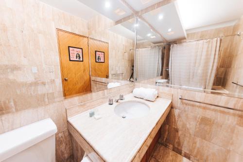een badkamer met een wastafel en een spiegel bij Selina Posada Miraflores in Lima