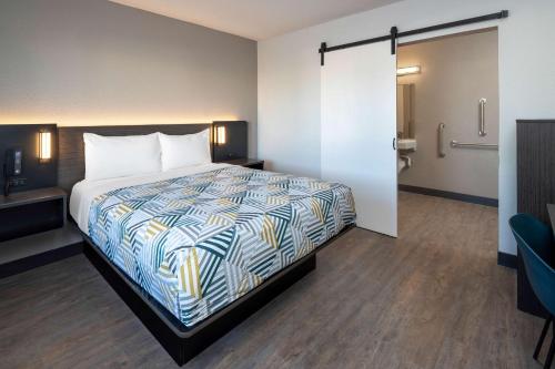 a hotel room with a bed and a bathroom at Motel 6-Fontana, CA in Fontana