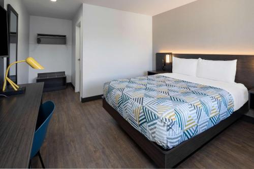 a hotel room with a bed and a desk at Motel 6-Fontana, CA in Fontana