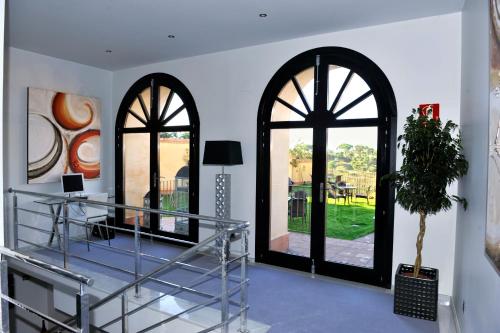 Habitación con 2 ventanas arqueadas y escalera. en Hotel Don Felipe, en Segovia