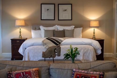 a bedroom with a bed with a couch and two lamps at The Greystone Inn in Lake Toxaway