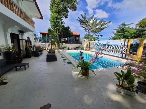 ein Pool neben einem Gebäude mit Pflanzen in der Unterkunft White Summerville Tourist Inn in Busuanga