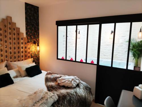 a bedroom with a bed and a large window at L'Atelier - Gîte & Spa in Épernay