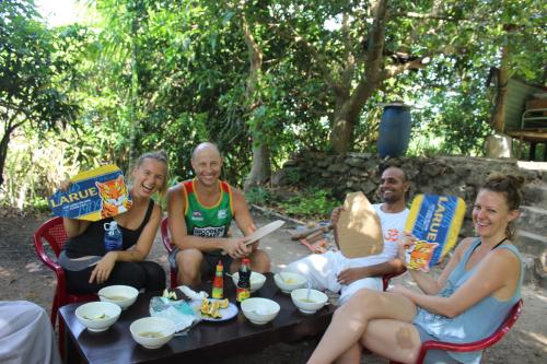 a group of people sitting around a table eating food at Cham Island Smiles Homestay in Tân Hiệp