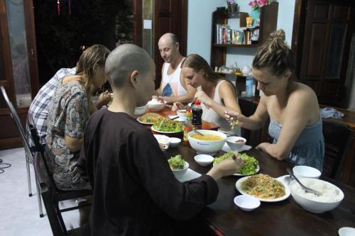 a group of people sitting around a table eating food at Cham Island Smiles Homestay in Tân Hiệp