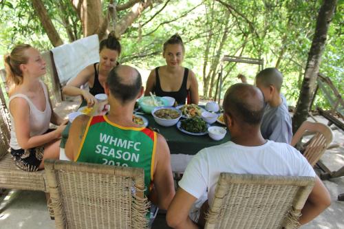 a group of people sitting around a table eating food at Cham Island Smiles Homestay in Tân Hiệp