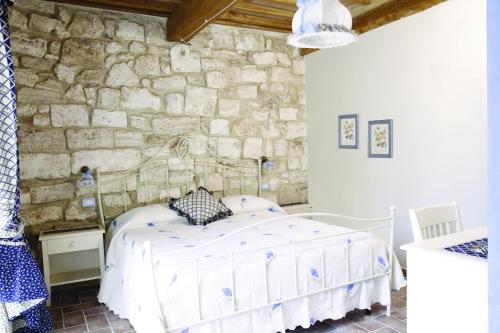 a bedroom with a bed in a stone wall at Agriturismo San Lorenzo in Serre di Rapolano