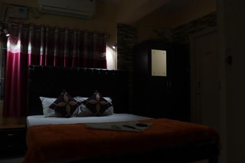 a bedroom with a bed and a window with red curtains at The Salvation Army RED SHIELD GUEST HOUSE in Kolkata
