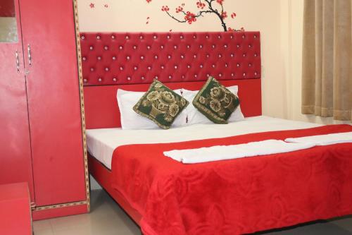 a bedroom with a red bed and a mirror at The Salvation Army RED SHIELD GUEST HOUSE in Kolkata