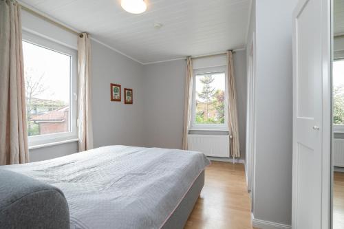 1 dormitorio blanco con 1 cama y 2 ventanas en Seestraße 30 a Auf dem Mehlboden, en Dahme