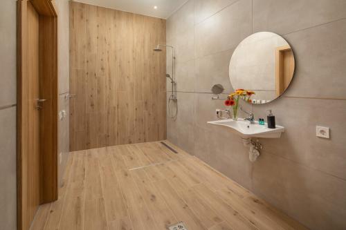 a bathroom with a shower and a sink and a mirror at Sziget Hotel in Nyíregyháza