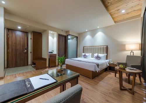 una habitación de hotel con una cama y un escritorio en Hotel Cachar Club, en Silchar