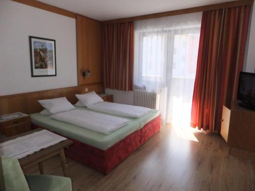 a hotel room with two beds and a window at Apart-Pension Oberreiter in Fusch an der Glocknerstraße