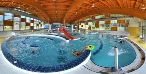 a large indoor swimming pool with people in it at FerienVilla Nimori in Lipno nad Vltavou