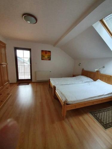 a large bedroom with a bed and a wooden floor at FerienVilla Nimori in Lipno nad Vltavou