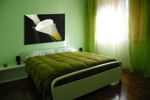 1 dormitorio con 1 cama con manta verde y ventana en A Caso, en Avellino