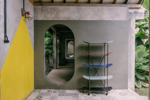 a spiral staircase in a wall with a round window at Dormitory at Semadi living in Sukawati